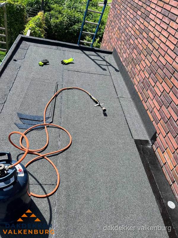 Plat dak met bitumen en brandgereedschap van dakdekkersbedrijf in Valkenburg