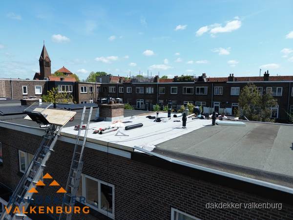 Dakdekkers aan het werk op plat dak in Valkenburg