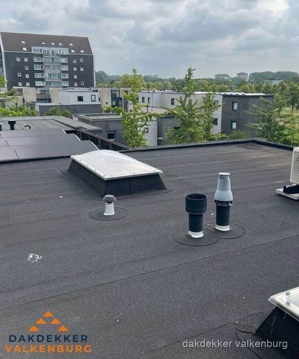 Groot plat dak met lichtkoepel en dakdoorvoeren in Valkenburg