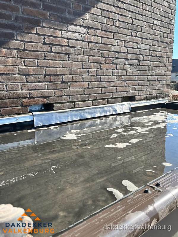 Stilstaand water op plat dak door slechte afwatering in Valkenburg Stilstaand water op plat dak door slechte afwatering in Valkenburg